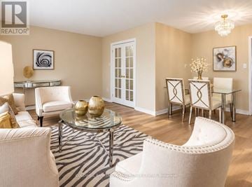 Newmarket (Huron Heights-Leslie Valley) apartment for rent - A living room with a glass coffee table and white chairs.