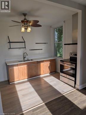 Brantford apartment for rent - A modern kitchen with wooden cabinets and a fan.