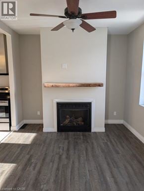 Brantford apartment for rent - A living room with a fireplace and a ceiling fan.