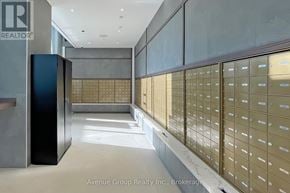 Vaughan (Vaughan Corporate Centre) condo for rent - A hallway with a row of mailboxes on the right and a black mailbox on the left.