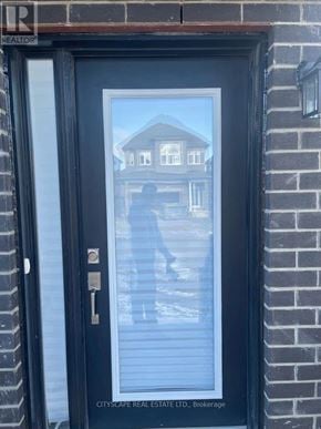 Barrie apartment for rent - A black door with a glass window and a key in the lock.