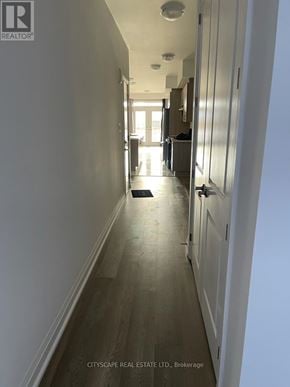 Barrie apartment for rent - A long hallway with wood floors and white walls.