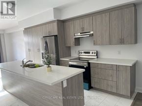 Barrie apartment for rent - A modern kitchen with a white countertop and wooden cabinets.