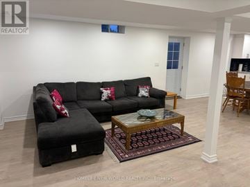 Richmond Hill (Oak Ridges Lake Wilcox) apartment for rent - A living room with a black couch and ottoman.