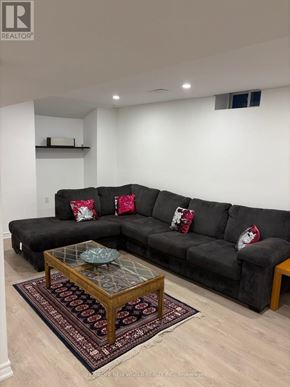 Richmond Hill (Oak Ridges Lake Wilcox) apartment for rent - A living room with a black couch and a glass coffee table.