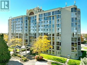 St. Catharines (Grapeview) condo for rent - A large building with a lot of windows and a green lawn in front.