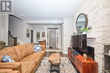 Niagara-On-The-Lake (Town) townhouse for rent - A living room with a brown couch and a stone fireplace.