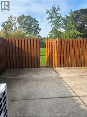 Windsor townhouse for rent - A brown wooden fence in front of a green field.