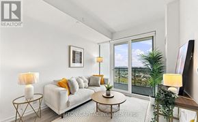 Vaughan (Vaughan Corporate Centre) condo for rent - A living room with a grey couch, a coffee table, and a large window with a view of the city.