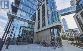 Vaughan (Vaughan Corporate Centre) condo for rent - A modern building with glass walls and a bicycle parked in front.