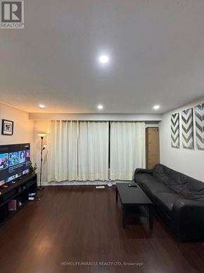 Toronto (West Humber-Clairville) apartment for rent - A living room with a black couch and a television.