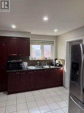 Toronto (West Humber-Clairville) apartment for rent - A kitchen with dark wood cabinets and stainless steel appliances.