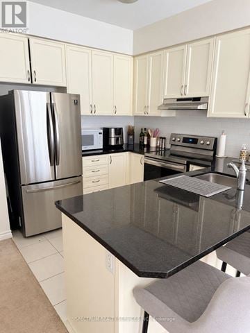 Brantford townhouse for rent - A kitchen with a black counter top and white cabinets.