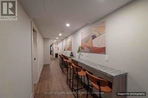 Toronto (Kensington-Chinatown) apartment for rent - A long hallway with a bar and chairs on the side.