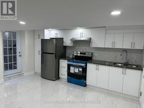 Vaughan (West Woodbridge) apartment for rent - A kitchen with a black fridge, white cabinets, and a blue dishwasher.