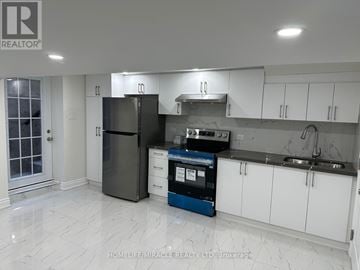 Vaughan (West Woodbridge) apartment for rent - A kitchen with a black fridge, white cabinets, and a blue dishwasher.