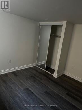 Vaughan (West Woodbridge) apartment for rent - A room with a white wall and a wooden floor with a white closet.