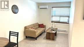 Toronto (Long Branch) apartment for rent - A living room with a couch, a chair, and a small table.