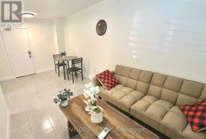 Toronto (Long Branch) apartment for rent - A living room with a beige couch and a wooden table with a vase of flowers on it.