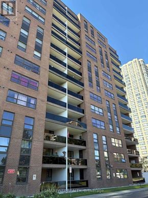 Brampton (Queen Street Corridor) condo for rent - A tall apartment building with balconies and a clear blue sky in the background.
