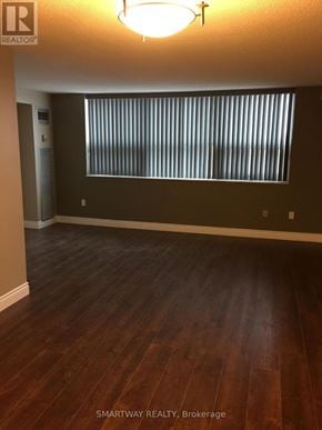 Brampton (Queen Street Corridor) condo for rent - A room with wooden flooring and a window with blinds.