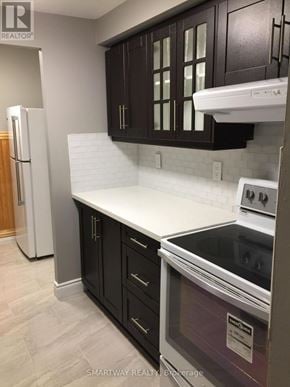 Brampton (Queen Street Corridor) condo for rent - A kitchen with a white counter top and black cabinets.