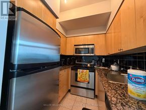 Toronto (Waterfront Communities) condo for rent - A kitchen with a stainless steel refrigerator and wooden cabinets.