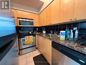 Toronto (Waterfront Communities) condo for rent - A kitchen with wooden cabinets and a stainless steel oven.