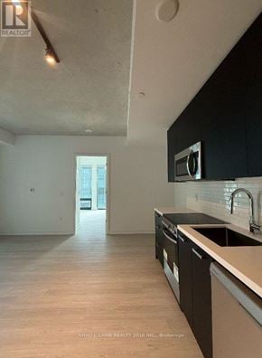 Toronto (Moss Park) condo for rent - A kitchen with black cabinets and a white counter top.