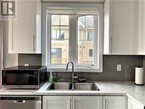 Hamilton (Hannon) townhouse for rent - A kitchen with a sink, microwave, and a window.