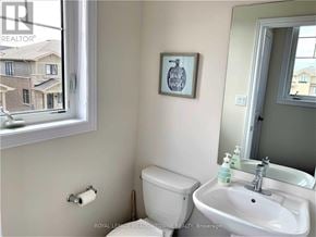 Hamilton (Hannon) townhouse for rent - A bathroom with a toilet, sink, and a window.