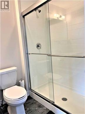 Hamilton (Hannon) townhouse for rent - A white toilet sits next to a glass shower door in a bathroom.