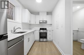 St. Catharines (Downtown) multi-family for rent - A modern kitchen with white cabinets and stainless steel appliances.