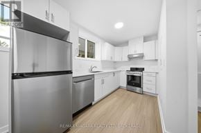 St. Catharines (Downtown) multi-family for rent - A modern kitchen with stainless steel appliances and white cabinetry.