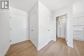 St. Catharines (Downtown) multi-family for rent - A white room with wooden floors and white walls, with a door open to another room.