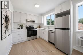 St. Catharines (Downtown) multi-family for rent - A modern kitchen with stainless steel appliances and white cabinets.