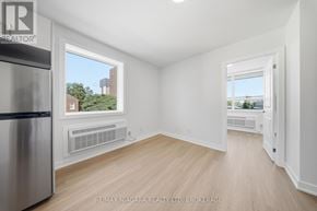 St. Catharines (Downtown) multi-family for rent - A white room with a window and a fridge.