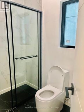 Toronto (Clairlea-Birchmount) duplex for rent - A white toilet in a bathroom with a glass door.