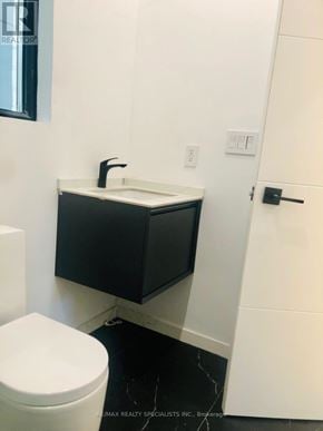 Toronto (Clairlea-Birchmount) duplex for rent - A white toilet sits next to a sink in a bathroom.