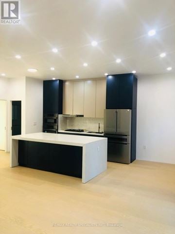 Toronto (Clairlea-Birchmount) duplex for rent - A modern kitchen with black cabinets and a white island.