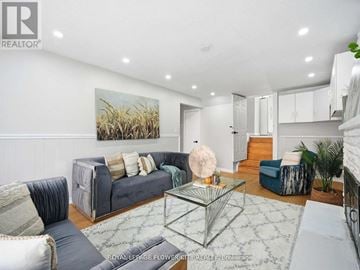 Brampton (Madoc) apartment for rent - A living room with a grey couch and a glass coffee table.