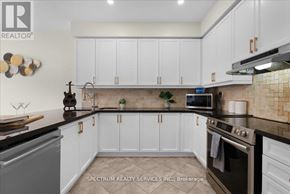 Milton (Be Beaty) apartment for rent - A kitchen with white cabinets and a black countertop.