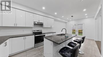 Southgate apartment for rent - A modern kitchen with white cabinets and a granite countertop.