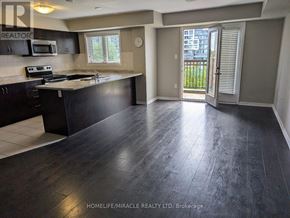 Oakville (Wm Westmount) townhouse for rent - A kitchen with dark wood floors and a black counter top.