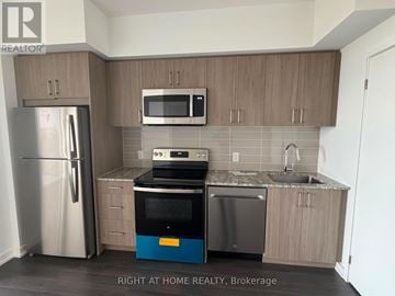 Toronto (Humber Heights) condo for rent - A kitchen with a refrigerator, microwave, oven, and sink.