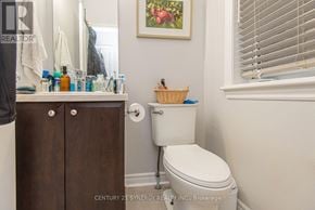 Ottawa townhouse for rent - A bathroom with a toilet, a cabinet, and a basket on the toilet.
