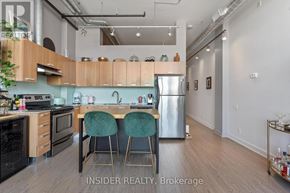Toronto (Niagara) condo for rent - A kitchen with wooden cabinets and a stainless steel refrigerator.