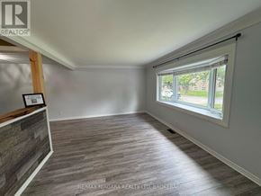 St. Catharines (Lakeport) apartment for rent - A room with a window and a wooden beam on the wall.