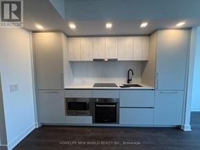 Toronto (North St. James Town) condo for rent - A modern kitchen with white cabinets and stainless steel appliances.