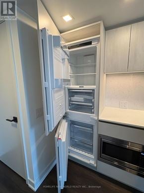 Toronto (North St. James Town) condo for rent - A kitchen with a white fridge and oven, and a white counter top.